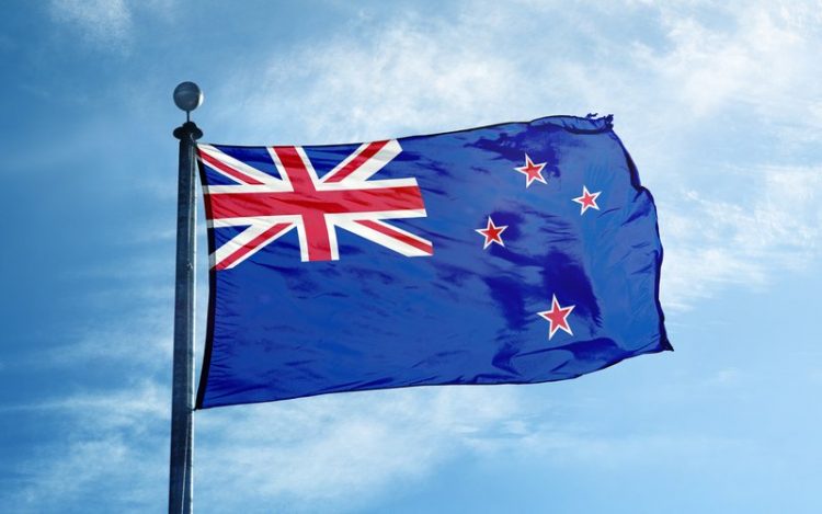 The New Zealand flag flying in a blue sky.